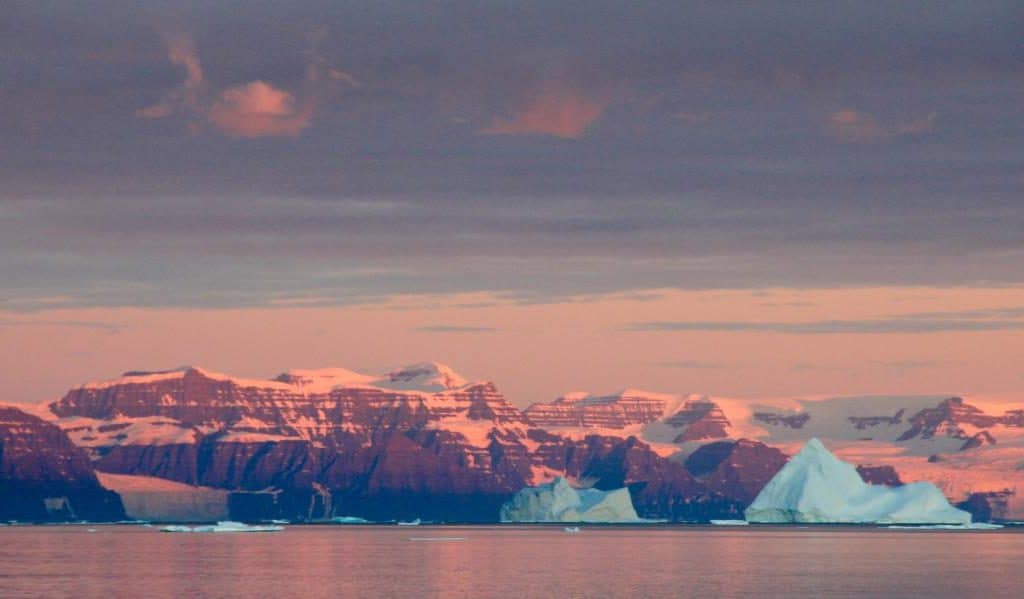 Golden light over the icy mountains in Greenland. 