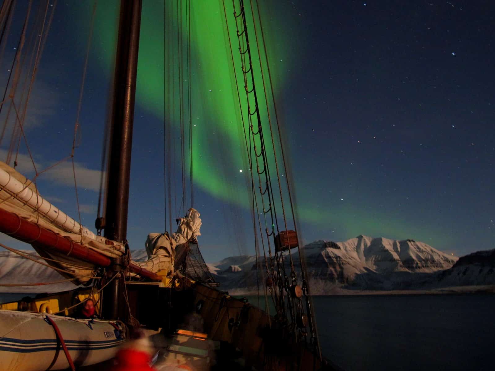 The northern lights from the deck of a tall ship. See the aurora with a polar expedition voyage through Classic Sailing.