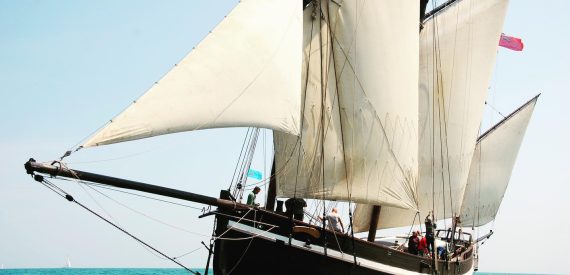 lugger grayhound under full sail on a green sea. sail cargo voyages and adventure holidays with classic sailing