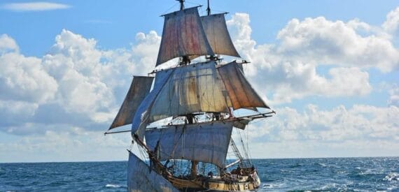 Sailing brig tallship Phoenix under full sail against a blue sky. Adventure sailing holidays with classic sailing