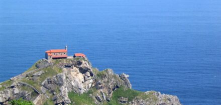 a building on a rocky headland overlooking the blue sea of the Bay of Biscay