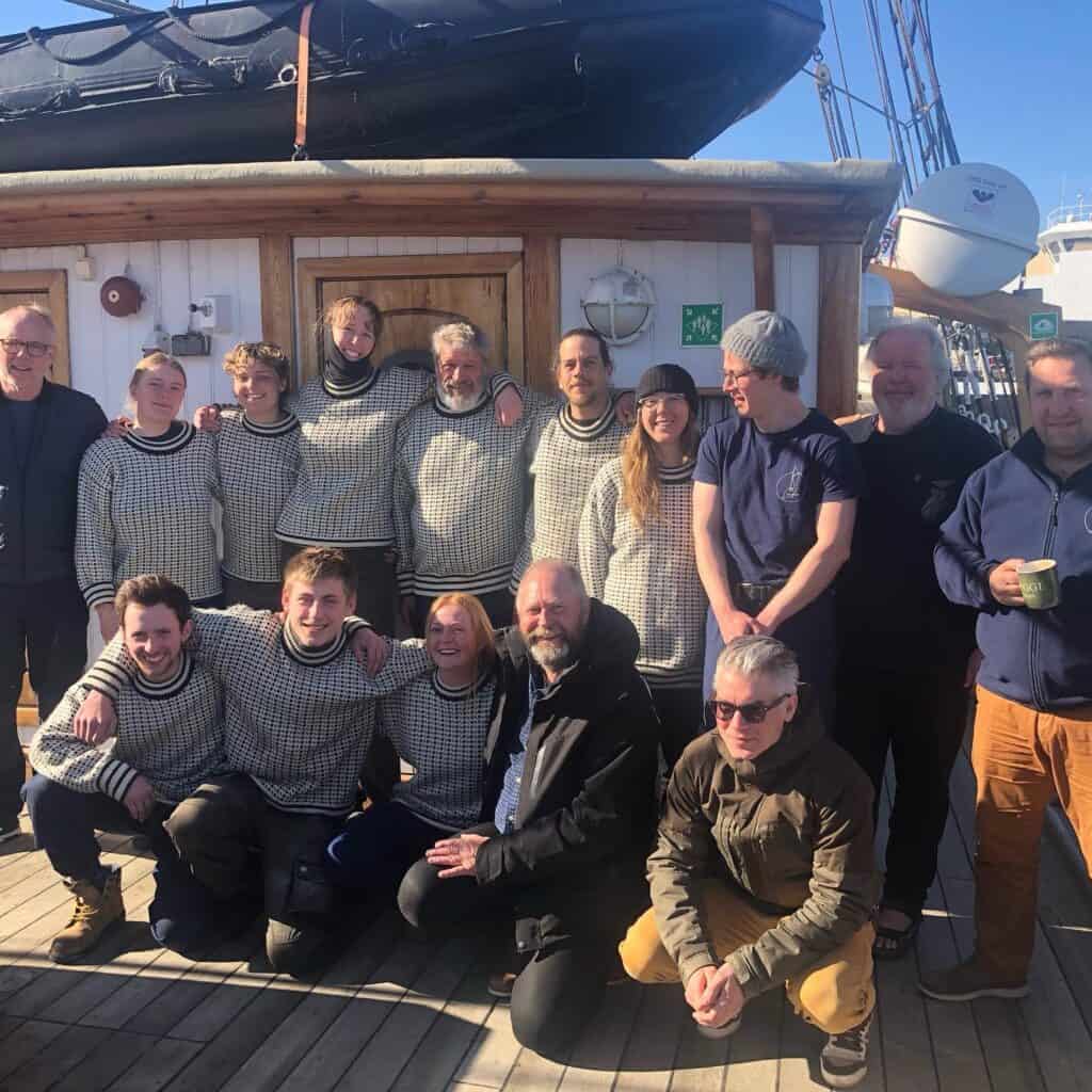 The crew of Linden pose in the sunshine. Join the ship for an arctic expedition voyage through Classic Sailing