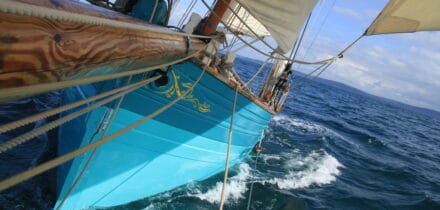 bowsprit view of pilot cutter Tallulah. spring sail with paintwork colour matching the turquoise seas