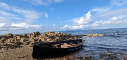 Grayhound lugger in the Hebrides. Rowing boat ashore.